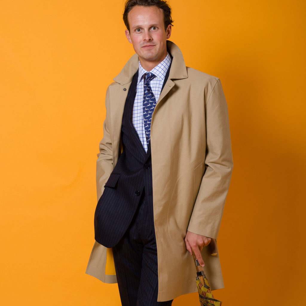 A man wearing a tan Duncan Mackintosh from Cordings over a blue tweed suit.