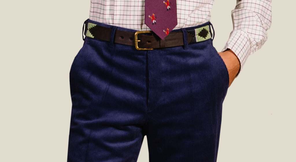 a man wearing a pair of navy blue 11 wale needlecord trousers made from supple Lancastrian cloth
