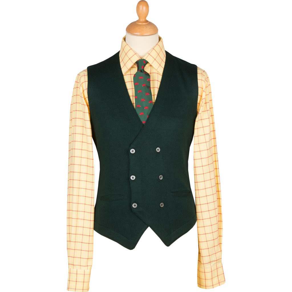 Mannequin wearing a bottle green double breasted merino waistcoat over a classic country shirt, with a bottle green tie