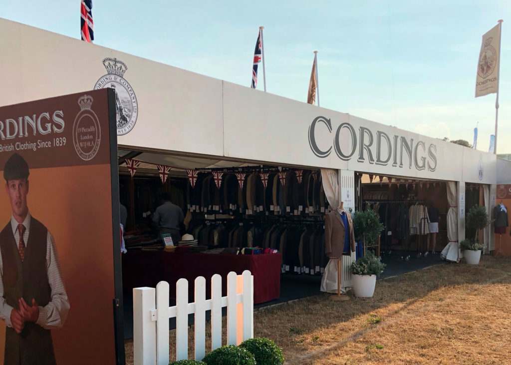 A Cordings stand at a country show, containing a variety of jackets, coats and country accessories for people to buy